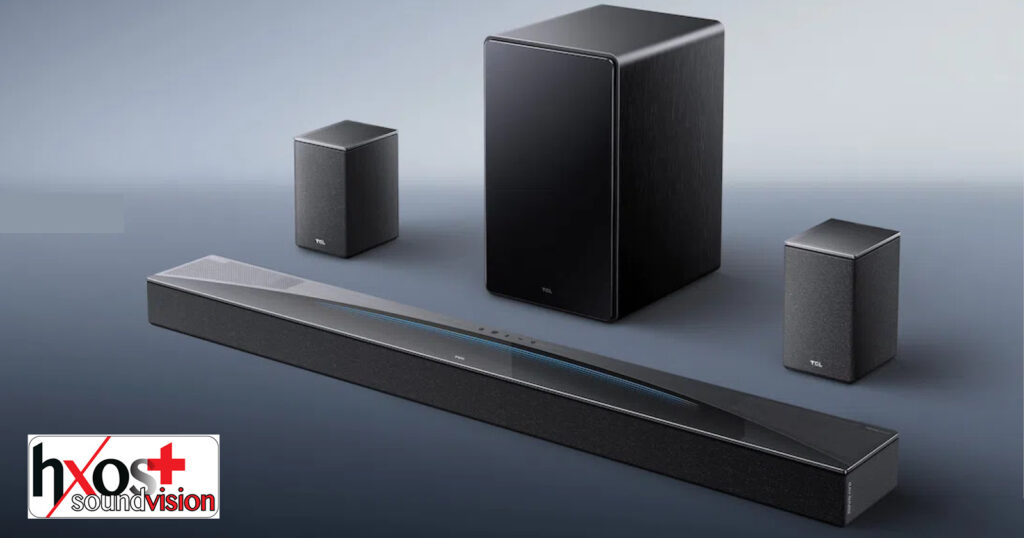 Ηχομπάρα TCL Q85 Pro με subwoofer και ασύρματα πίσω ηχεία, τοποθετημένη σε μοντέρνο σαλόνι, αναδεικνύοντας τον κομψό σχεδιασμό και τις δυνατότητες surround ήχου.