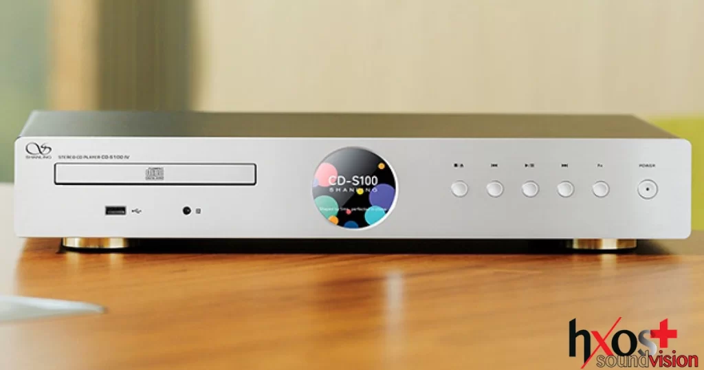 CD Player Shanling CD-S100 V25 σε  ασημί χρώμα, με πλήκτρα πρόσοψης και οθόνη, τοποθετημένος σε high-end σύστημα ήχου.