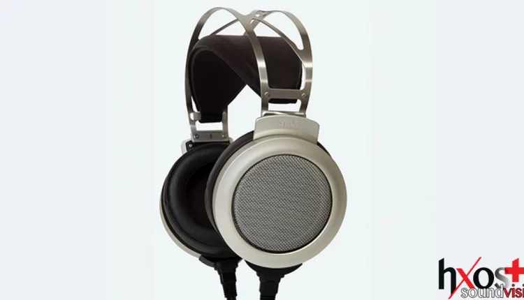 Ηλεκτροστατικά ακουστικά Stax SR-007S με δερμάτινα μαξιλαράκια, vintage σχεδίαση και μεταλλική γέφυρα κεφαλής, τοποθετημένα σε ξύλινη βάση.