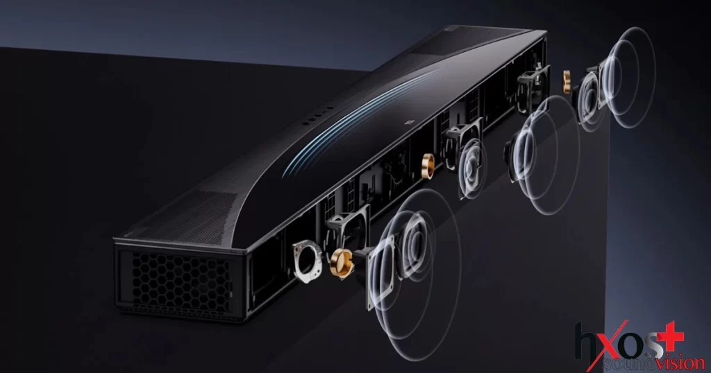 Ηχομπάρα TCL Q85 Pro με subwoofer και ασύρματα πίσω ηχεία, τοποθετημένη σε μοντέρνο σαλόνι, αναδεικνύοντας τον κομψό σχεδιασμό και τις δυνατότητες surround ήχου.
