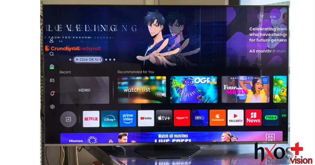 ηλεόραση Hisense 65U8Q 2025 Mini LED 65 ιντσών, τοποθετημένη σε επιτραπέζια βάση, με εμφάνιση οπίσθιων θυρών (USB-C, HDMI 2.1, USB 3.0) και τηλεχειριστήριο με ηλιακή φόρτιση.